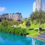 Vista del Parque La Mexicana con su lago artificial, áreas verdes y edificios modernos, accesible por el Tren Interurbano México Toluca.